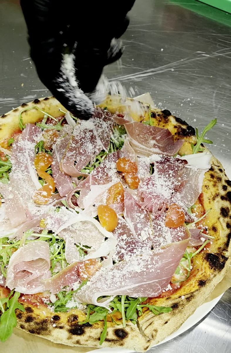 Filmuleț cu parmezan presărat pe o pizza Sami's